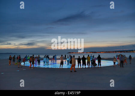 Menschen am Denkmal für die Sonne, Pozdrav Suncu, Architekt von Nikole Bašića bei Dämmerung, Zadar, Dalmatien, Kroatien Stockfoto