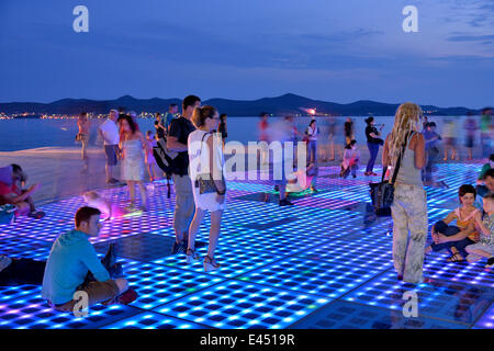 Menschen am Denkmal für die Sonne, Pozdrav Suncu, Architekt von Nikole Bašića bei Dämmerung, Zadar, Dalmatien, Kroatien Stockfoto