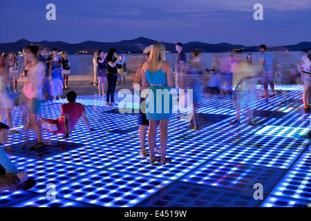 Menschen am Denkmal für die Sonne, Pozdrav Suncu, Architekt von Nikole Bašića bei Dämmerung, Zadar, Dalmatien, Kroatien Stockfoto