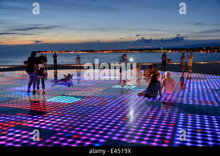 Menschen am Denkmal für die Sonne, Pozdrav Suncu, Architekt von Nikole Bašića bei Dämmerung, Zadar, Dalmatien, Kroatien Stockfoto