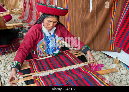 Ältere Frau mit einem Hut, Quechua-Indianer in traditioneller Tracht, die Arbeit an einem Webstuhl, Cinchero, Urubamba-Tal, Peru Stockfoto