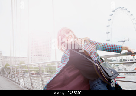 Porträt der jungen weiblichen Touristen geschwungen auf Golden Jubilee Fußgängerbrücke, London, UK Stockfoto