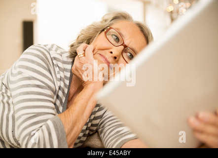 Ältere Frau liest mit digital-Tablette Stockfoto