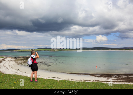 Weibliche Vogelbeobachter mit Fernglas Vögel an der Westküste zu beobachten. Balranald RSPB Nature Reserve North Uist Äußere Hebriden Western Isles Schottland Großbritannien Stockfoto