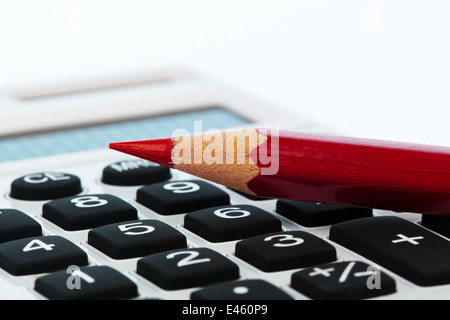 Einen roten Stift und einen Taschenrechner. Bildsymbol für optimieren und sparen Stockfoto