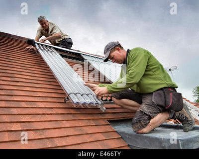 selbst Hausbau, Rohre Mann Montage Solar-thermische Warmwasser Veissmann Süd gerichteten Dach Stockfoto