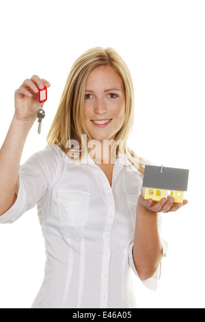 Eine junge Frau mit einer Modell-Haus und Wohnung-Tasten. Stockfoto