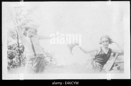 Ein Vintage-Foto von Helen Richey, einer der ersten Piloten in den USA, fotografiert draußen mit zwei anderen Frauen in Tanzpositionen. Alle tragen Hüte und Richey lächelt. Dieses Bild zeigt die frühen Tage der Luftfahrt in einem lustigen, offenen Moment. Stockfoto