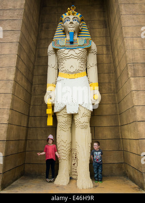 Zwei Kinder stehen neben einer riesigen Statue des Tutanchamun aus Lego-Steinen im Legoland Windsor in England hergestellt Stockfoto