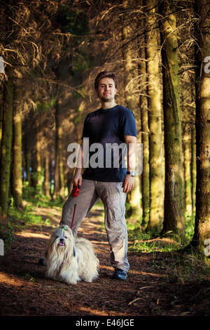 Junger Mann und Shih Tzu Hund Portrait im Wald. Stockfoto