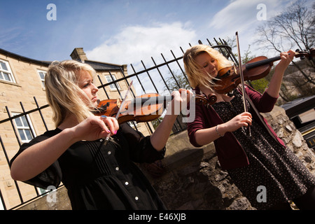 UK, Derbyshire, Peak District, Bakewell, Riverside, zwei junge Frauen folk Fiddlers als Straßenmusikant Stockfoto