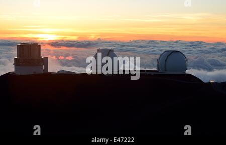 Ein Auto zu fahren neben Observatorien auf dem Gipfel des Mauna Kea (Hawaii) während des Sonnenuntergangs. Stockfoto