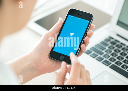 Person, die eine brandneue Apple iPhone 5 s mit Twitter-Logo auf dem Bildschirm. Stockfoto