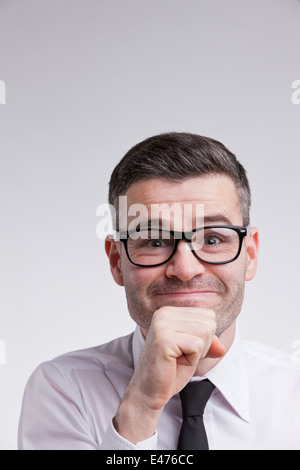 ein nerdy Mann mit einer guten Idee im Auge mit Brille und lächelt in die Kamera: er ist sehr zufrieden Stockfoto