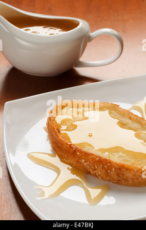 Croutons Honig geröstete Weißbrot Dessert kalorienreiche süße neue Schale Platte Gießen Biene Toast Essen hausgemachte niemand appetitlich lecker Stockfoto