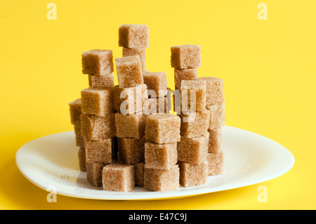 unraffiniertes Klumpen Stücke Pyramide Platte Hintergründe Beige Schale braun Candy Cane Keramik Ton Farbe Kristall Cube Frühstückstasse Zucker Stockfoto