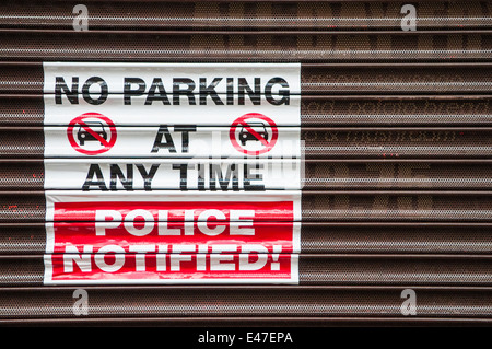 Melden Sie einen Shop-Shutter "No Parking jederzeit. Polizei informiert! " Stockfoto