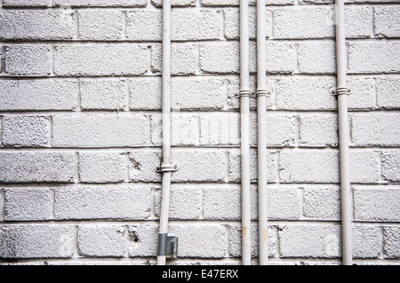 Weiße Wand und elektrische Leitungsrohre Stockfoto
