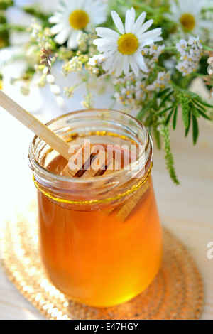 Glas voll von Honig und Wildblumen Stockfoto