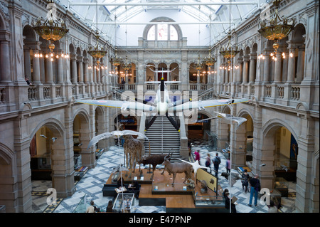 Besucher im Kelvingrove Art Gallery and Museum mit dem zweiten Weltkrieg Spitfire Flugzeug Ausstellung auf dem Display in Glasgow, Schottland Stockfoto