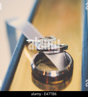 Trauringe auf ein Buch mit Band zwischen ruht. Stockfoto