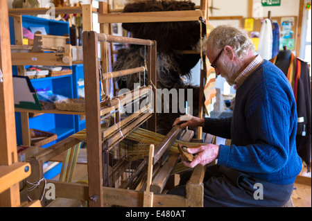 Handwerker mit traditionellen Webstuhl zum Weben Wolle für handgefertigte Wolle Schal in Croft Wolle Weber in den Highlands von Schottland Stockfoto