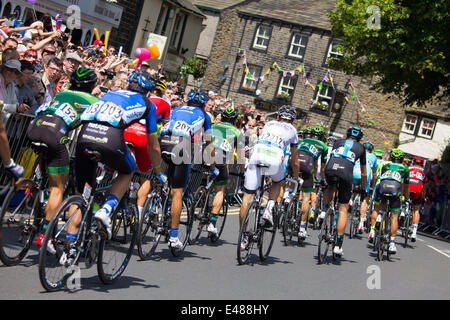 Skipton, North Yorkshire, UK. 5. Juli 2014 – erstrahlt The North Yorkshire Marktstadt von Skipton in Sonnenschein als 2014-Tour de France Grand Depart durchläuft. Die Stadt zog angeblich, Massen von mehr als 20.000 Menschen um dem Ereignis beizuwohnen. Das Hauptfeld hinter den drei Fahrern in der Ausreißergruppe, Reisen die Stadt High Street hinunter. Bildnachweis: Thomas Holmes/Alamy Live-Nachrichten Stockfoto