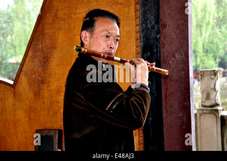 PENGZHOU, CHINA: Musiker spielt eine Bambus di Zi (eine chinesische Äquivalent einer Flöte) in einem Pavillon im Park Pengzhou Stockfoto