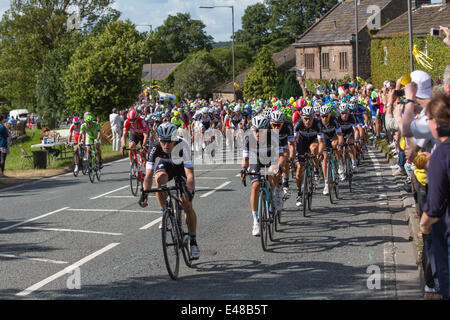 Harrogate, Nordyorkshire. 5. Juli 2014. Ein dicht gepackten Hauptfeld betritt Yorkshire Dorf von Killinghall, 3 Meilen vom den ersten Tag beenden in Harrogate. Copyright Ian Wray/Alamy Live-Nachrichten Stockfoto