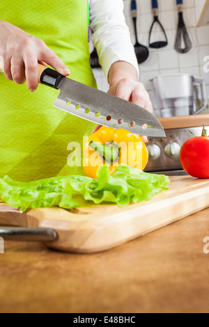 Frauenhand schneiden frische Paprika in der Küche Stockfoto