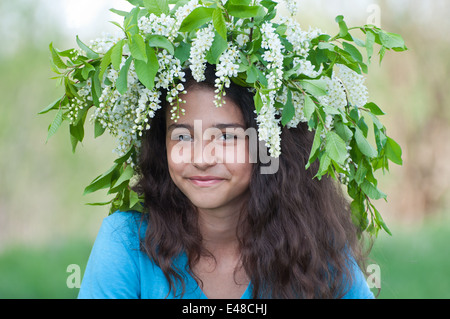 Mädchen Teen Natur Kranz Frühjahr Kirschblüten Teenager schön süß positive brünette Haare lange lockige dunkle Lächeln eine offene Ki Stockfoto