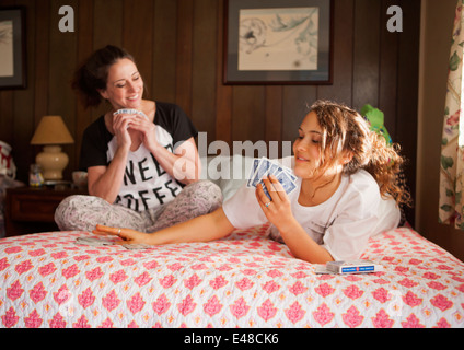 Mutter und Tochter Spielkarten auf Bett Stockfoto