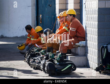 Fukang, China, 6. Juli 2014.  Retter warten für Arbeit vor einem Eingang der Grube, wo eine Gas-Explosion 17 Bergleute bei der Nr. 1 Kohle-Grube von Dhuangshan Yunxin Coal Mining Co., Ltd, 120 Kilometer von Urumqi, der Hauptstadt von Nordwesten Chinas Xinjiang Uygur Autonome Region, 6. Juli 2014 fallen. Die Explosion geschah am 20:43 am Samstag, wenn 20 Leute in der Mine gearbeitet haben. Drei von ihnen wurden gerettet. Retter strömen Stickstoff in die Mine, die Gaskonzentration zu verdünnen. Bildnachweis: Xinhua/Alamy Live-Nachrichten Stockfoto