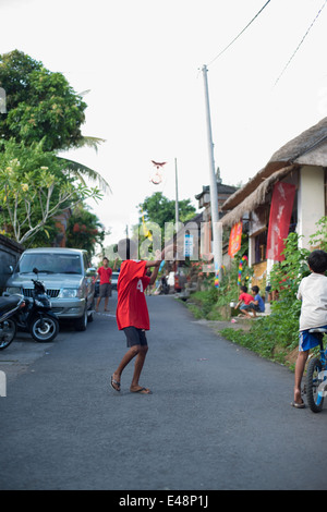 Kinder lassen Sie einen Drachen in den Straßen von Ubud, Bali, Indonesien Stockfoto