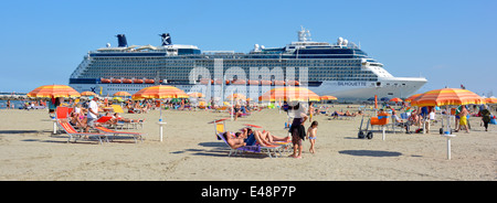 Bunte Liegestühle & Sonnenschirm Sonnenschirm Sonnenschirm Familie Strand Kreuzfahrt Linienschiff Celebrity Silhouette am Port Corsini Ravenna Emilia Romagna Italien Stockfoto