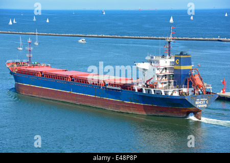 "Behcet C" Bulk-Carrier fährt Hafen Ravenna entlang Candiano Kanal Position heraus in die Adria Segeln Boote über Wellenbrecher Stockfoto