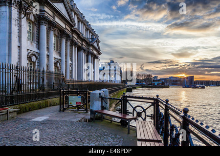 Blick auf den Sonnenuntergang von der Old Royal Naval College und die Themse auf der Themsepromenade in Greenwich, London, UK Stockfoto