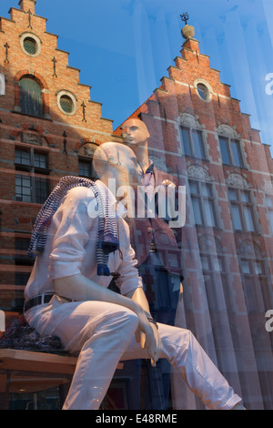 Brügge, Belgien - 11. Juni 2014: Die Figur in der Fensterscheibe und der Spiegel der typischen Backsteinhäuser. Stockfoto