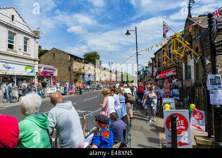 Menschenmassen entlang der Route der Stufe 2 der 2014 Tour de France im Zentrum von West Yorkshire Stadt des Holmfirth, in den Stunden vor der Ankunft der Radfahrer, UK Stockfoto