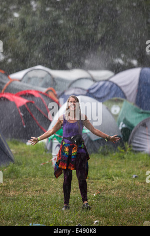 Glückliche Frau tanzen im Regen in der Nähe von John Peel-Phase, während des Gewitters beim Glastonbury Festival 2014 Stockfoto