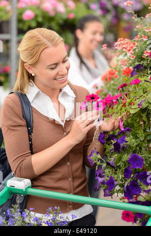 Lächelnde Frau im Garten-Center Blick auf bunten Blumen einkaufen Stockfoto