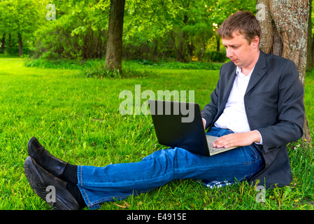 erfolgreicher Geschäftsmann mit Laptop im park Stockfoto