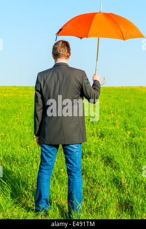 konzeptionelle Foto männlich in der Natur mit einem Regenschirm Stockfoto