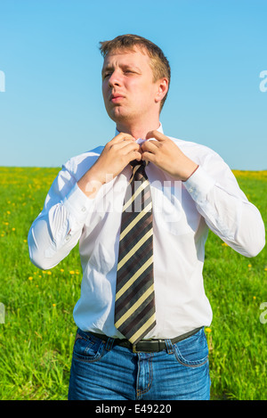 Porträt eines Geschäftsmannes, richtet seine Krawatte im Feld Stockfoto