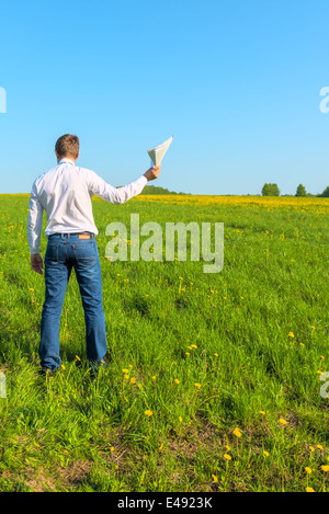 Mann in weißen Hemd im Feld mit Papieren Stockfoto