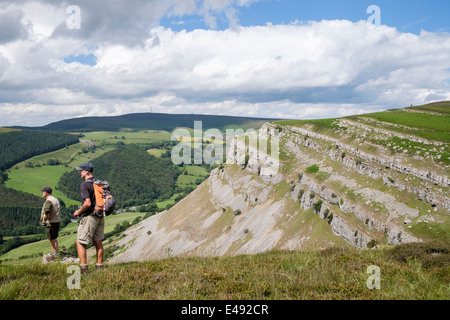 Wanderer auf Eglwyseg Berg mit Kalkstein Escarpment über Tal im Sommer. Llangollen Denbighshire North Wales UK Großbritannien Stockfoto