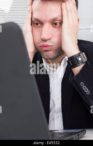 Business Mann bei der Arbeit und haben Problem mit Laptop auf dem Bildschirm und seinen Kopf mit beiden Händen, Geschäftsmann am Schreibtisch sitzen, Computer Virus oder Fehler Konzept Stockfoto