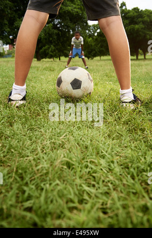 Kinder spielen Fußball-Spiel im Park, mit textfreiraum auf Rasen und Fokus auf Fußball-ball Stockfoto