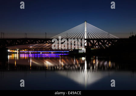 Beleuchtete Brücke bei Nacht und im Wasser gespiegelt. Swietokrzystki Brücke. Stockfoto