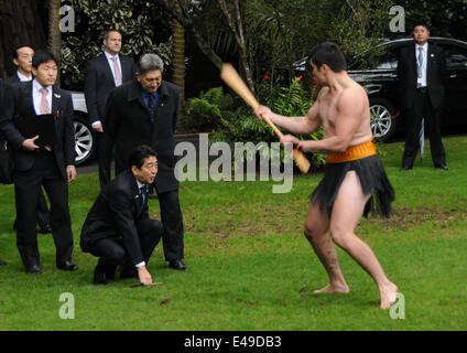 (140707)--AUCKLAND, 7. Juli 2014 (Xinhua)--A Maori Krieger führt traditionelle Maori Challenge vor der Besuch der japanische Premierminister Shinzo Abe (L, vorn) auf dem Rasen des Government House in Auckland, New Zealand, 7. Juli 2014. Als eine Tradition würde Maori-Krieger Schub ein Stück Holz oder lassen Sie auf den Boden zu sehen, ob der Besucher in Frieden oder Herausforderung kommt. Wenn der Besucher den Artikel nimmt und es langsam an der Stammesführer übergibt, würde er als ein Besucher des guten Willens angesehen werden. Neuseeland ist die erste Etappe der japanische Premierminister Shinzo Abe drei Land besuchen Stockfoto